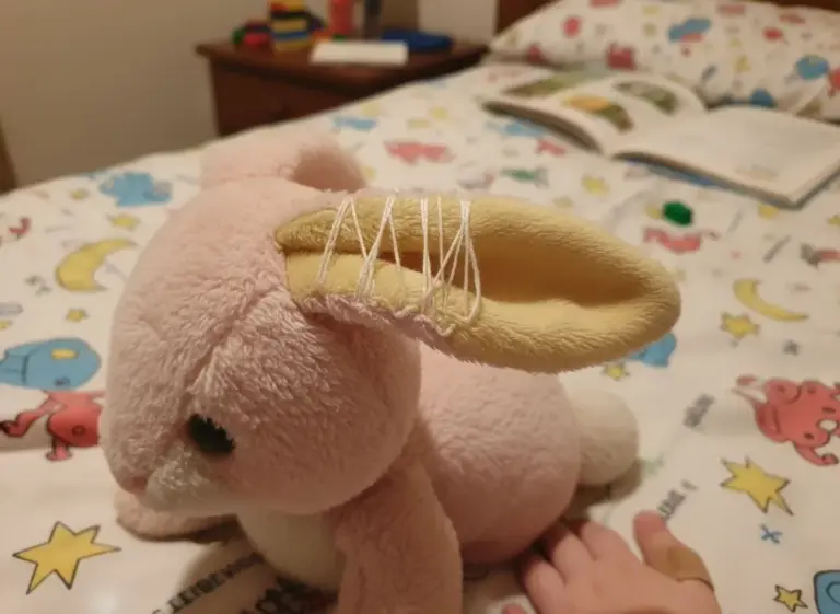 Photo de Pompon, lapin rose pâle aux oreilles jaunes